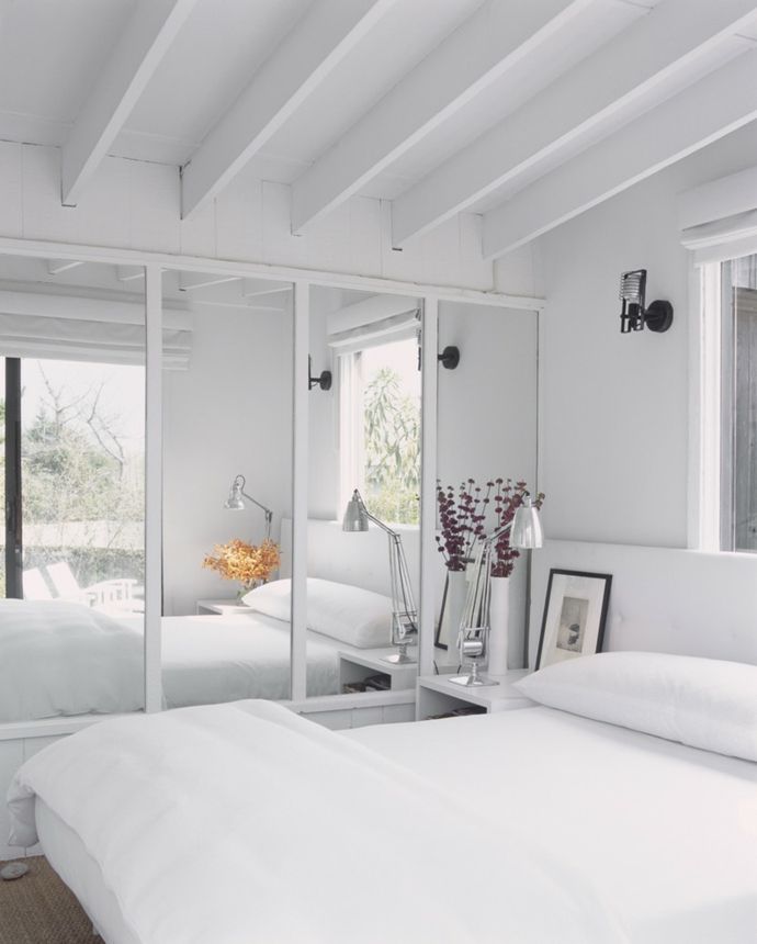 Double bed wardrobe mirrored doors ceiling beams white bedroom design
