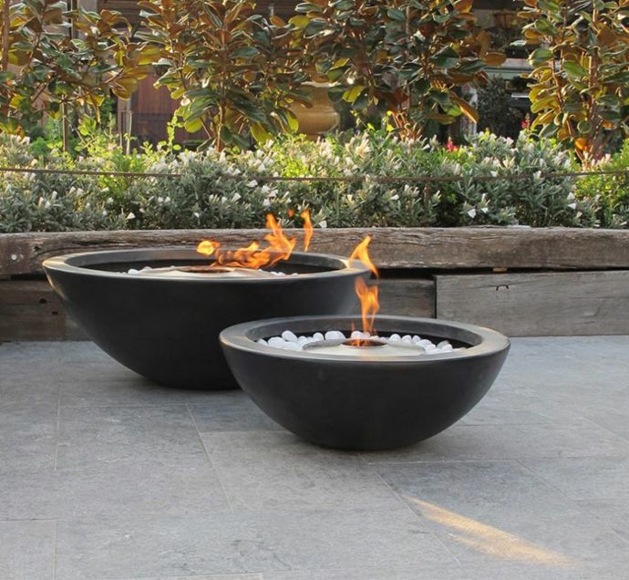 Outdoor garden area Fireplace stones Hozl plants Shrubs around decoration made of concrete