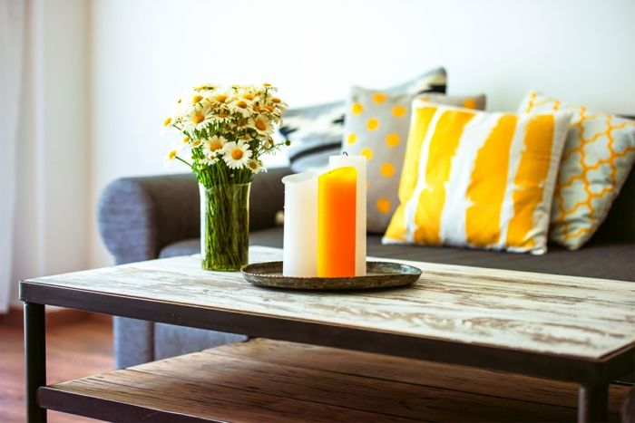 Bunte Gestaltung durch Kontraste-Gemütliche Kaffeeecke im modernen Wohnzimmer-Deko Ideen Einrichtung Wohnzimmer Orange Hellgrau Kerzen Schnittblumen Holztisch