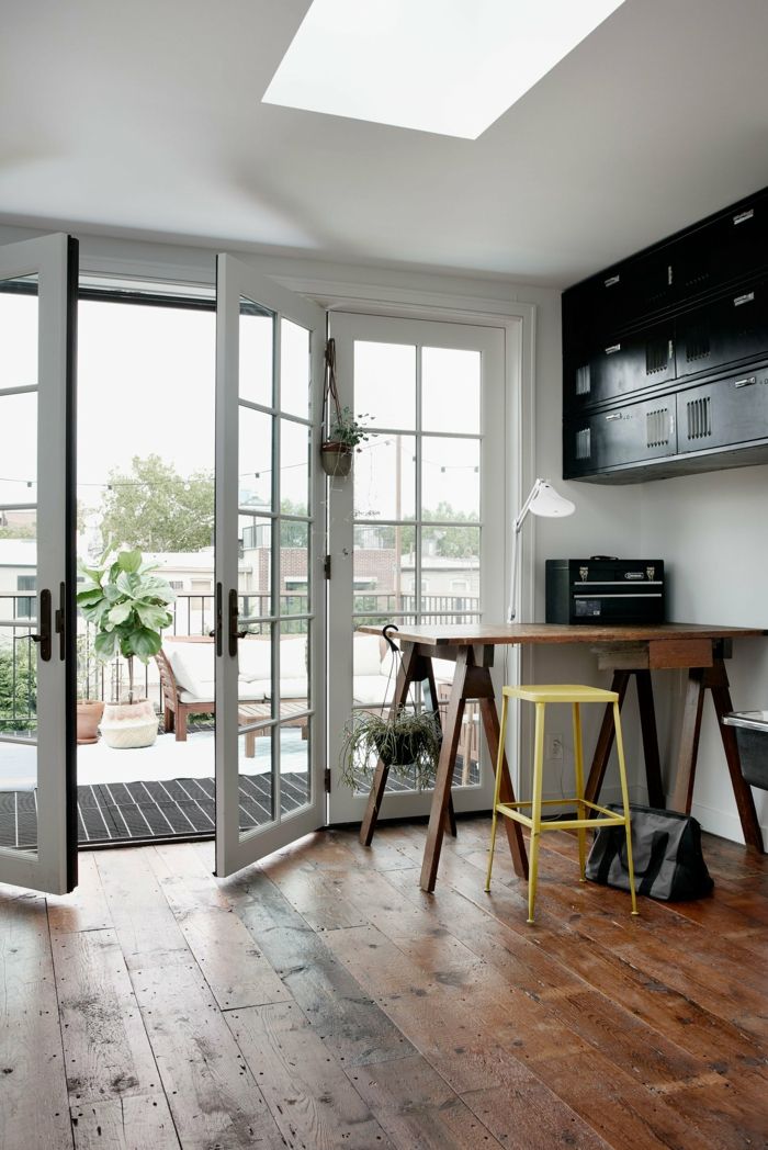 Natürliche Materialien wie Holz sorgen für ein wohnliches Ambiente-Ursprünglicher Holzboden aus dem 20.Jhdt-Wohnzimmer Familienhaus französische Türen in Weiß Arbeitstisch minimalistisch