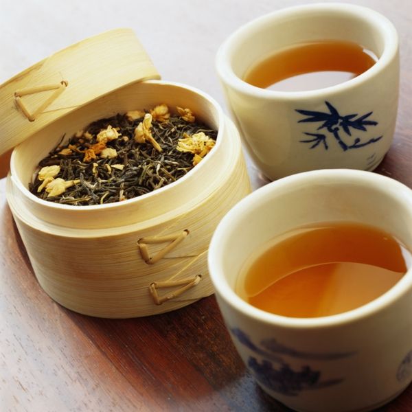 Teetassen und getrocknete Teeblätter im Bambus-Behälter-Schwarzer Tee Kräutertee Teesorten Antioxidationsmittel Herzerkrankungen Infarktrisiko senken Stressreduzierung