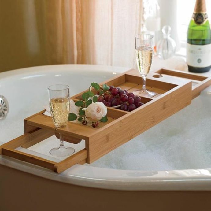 Bathtub shelf made of wood with placed champagne glass bathtub shelf made of wood