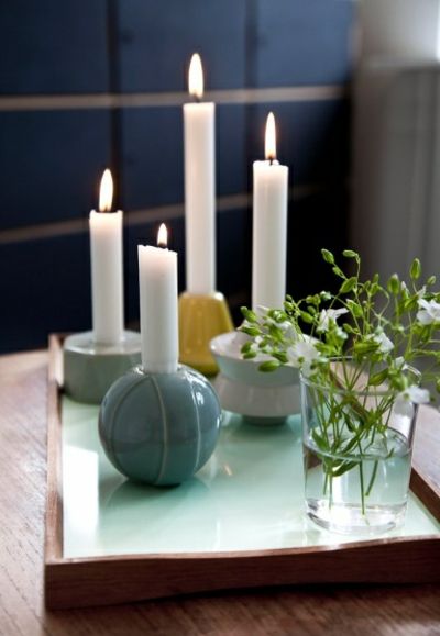 Weiße Stabkerzen und runden Kerzenhalter-Kerzenständer im Interieur