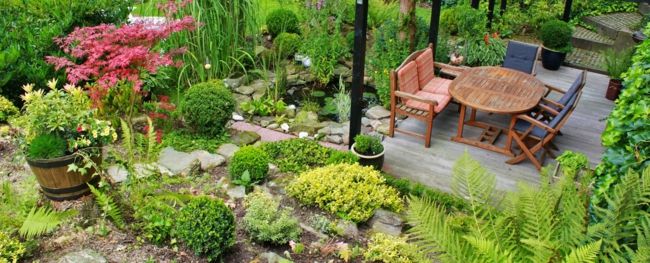 small pretty garden with a round wooden garden table garden decorations - ideas