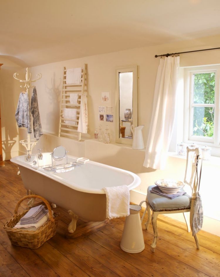 Vintage style freestanding bathtub in front of window in bathroom of a country house