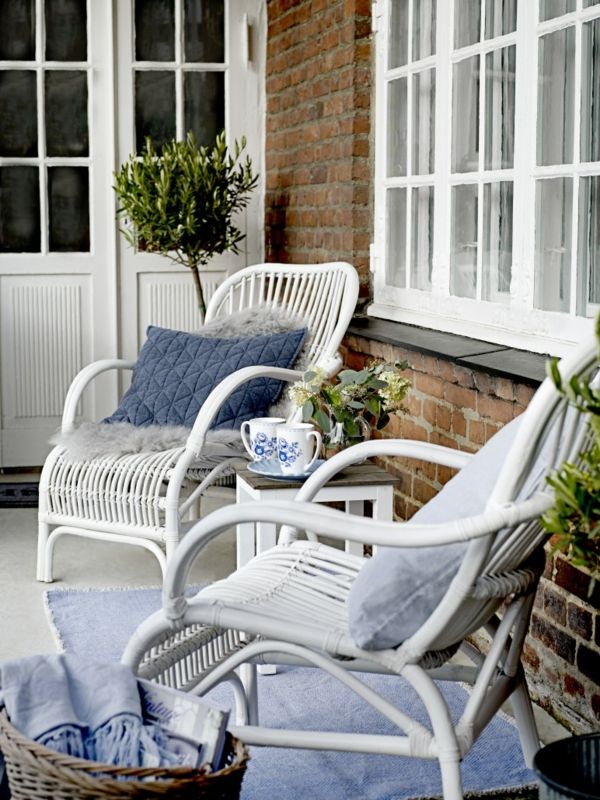 Comfortable wicker armchairs with fabric cushions create a sea feeling on the terrace