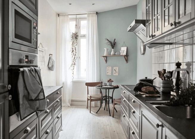 Kitchen in an old building, eclectic furnishings, classic gray-blue wall color contrast
