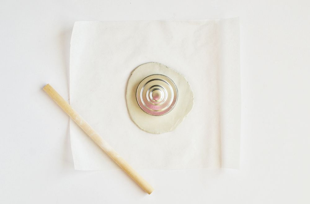 Roll out the clay on parchment paper to keep the table clean.