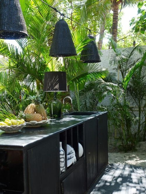 stylish outdoor kitchen in black hanging lamp palm trees