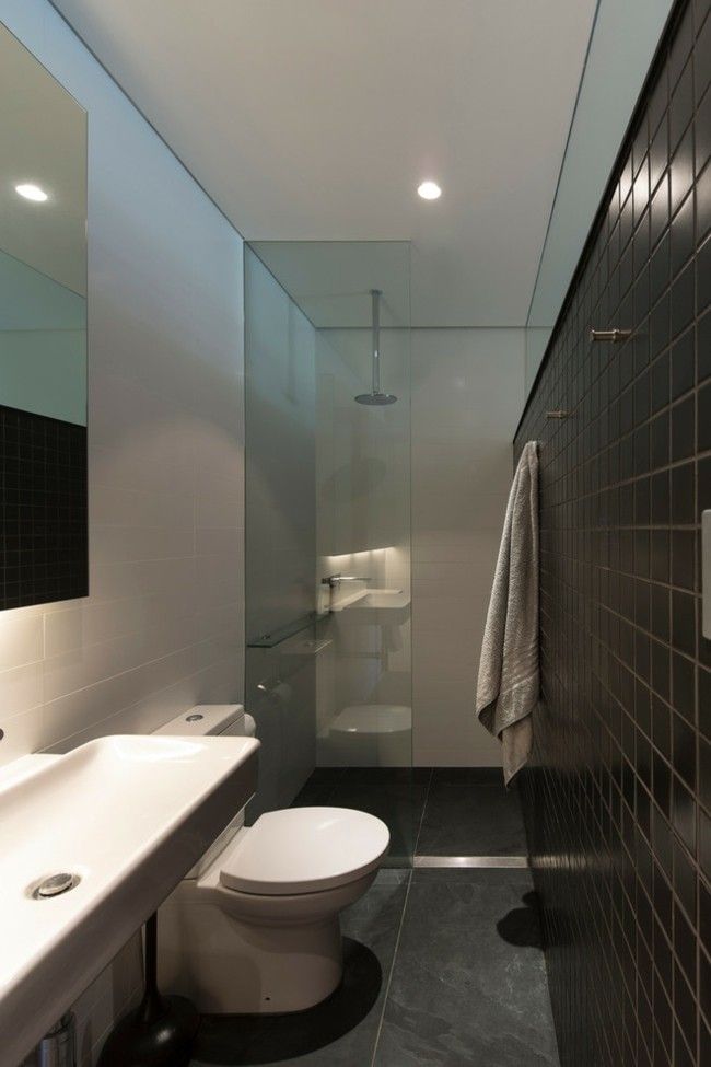 Small bathroom set up gray wall floor tiles glass partition