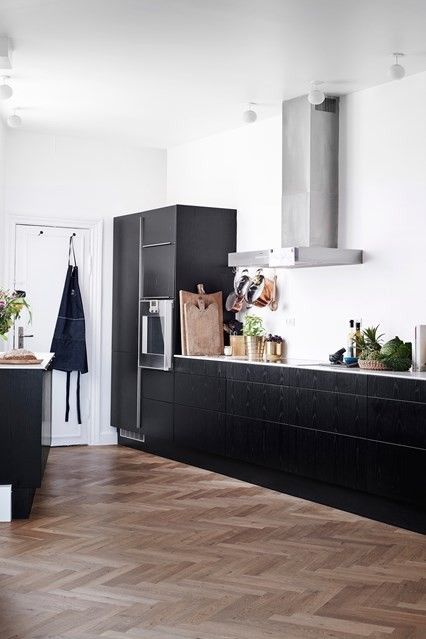 Black kitchen cabinets, white work surfaces, white walls