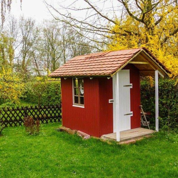 kleines Gartenhaus einfaches Design in Ziegelrot gestrichen