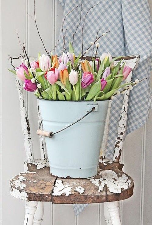 Dekorieren mit Tulpen schöne Blumen im Eimer Vintage Stuhl