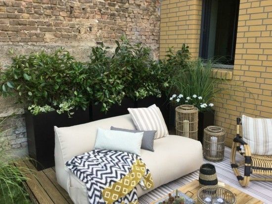 weißes Sofa niedrig exotische kleine Details grüne Pflanzen Terrasse gestalten