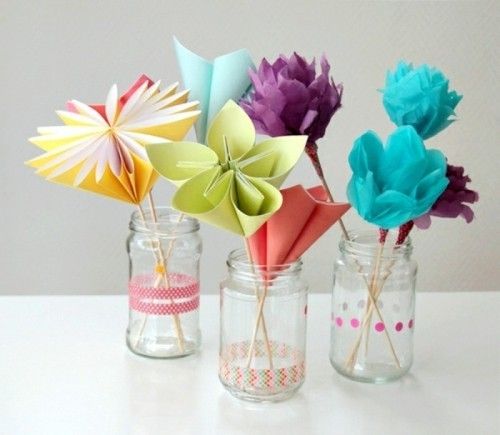 Blumen aus Papier in verschiedenen Farben in Gläsern