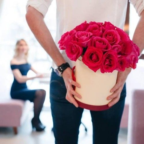 Bouquet rote Rosen in weißer Box ein Mann schenkt sie seiner geliebten Frau