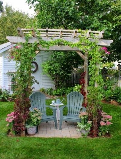 Eine behagliche Kaffeeecke für zwei im Garten unter dem Rosenbogen arrangiert