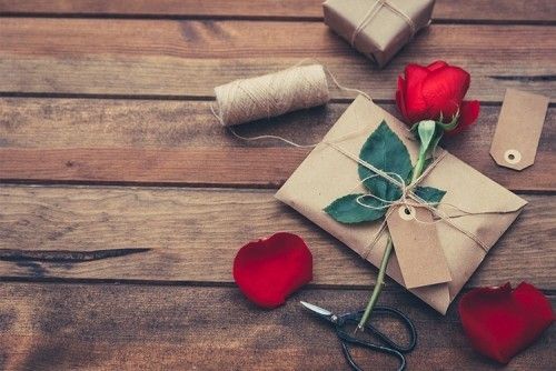 Einfaches Päckchen mit roter Rose geschmückt drückt Romantik aus