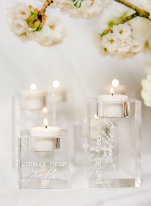 Schickes Design weiße Kerzen zarte Blüten im Hintergrund Hochzeitdeko