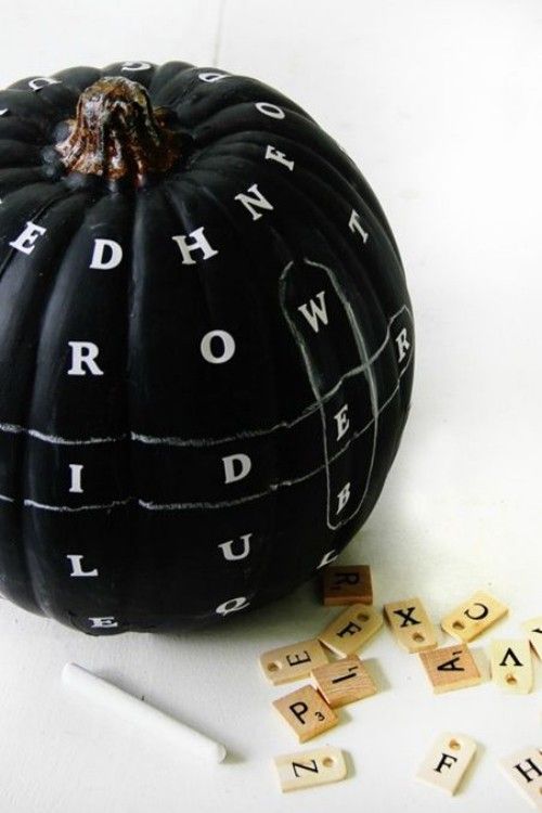 Weiße Buchstaben auf schwarz bemaltem Kürbis Herbstdeko drinnen