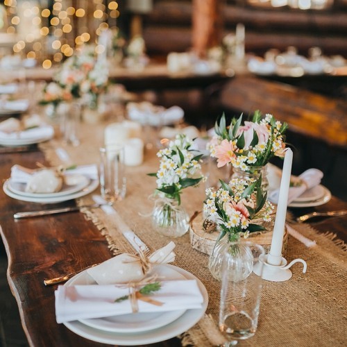 Dekorationen aus Holz und Wildblumen serviert auf dem festlich bedeckten Tisch