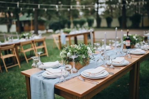 Die Stühle und der Tisch für die Gäste mit Kerzen dekoriert mit Besteck und Geschirr serviert und mit Tischdecke