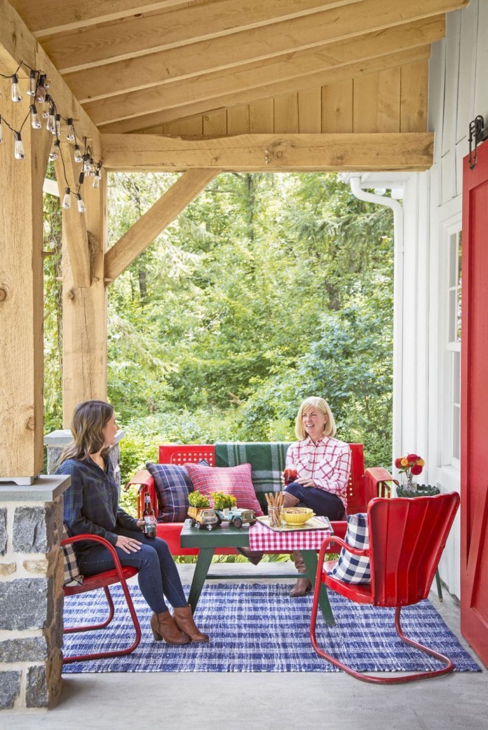Überdachte Terrasse bunte Outdoor Möbel in Rot Deko Kissen bunter Teppich viele warme Farben
