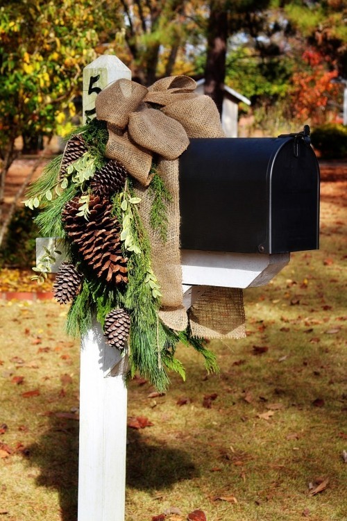 Weihnachtsdeko Hauseingang grüne Zweige Zapfen braune Schleife Briefkasten dekorieren