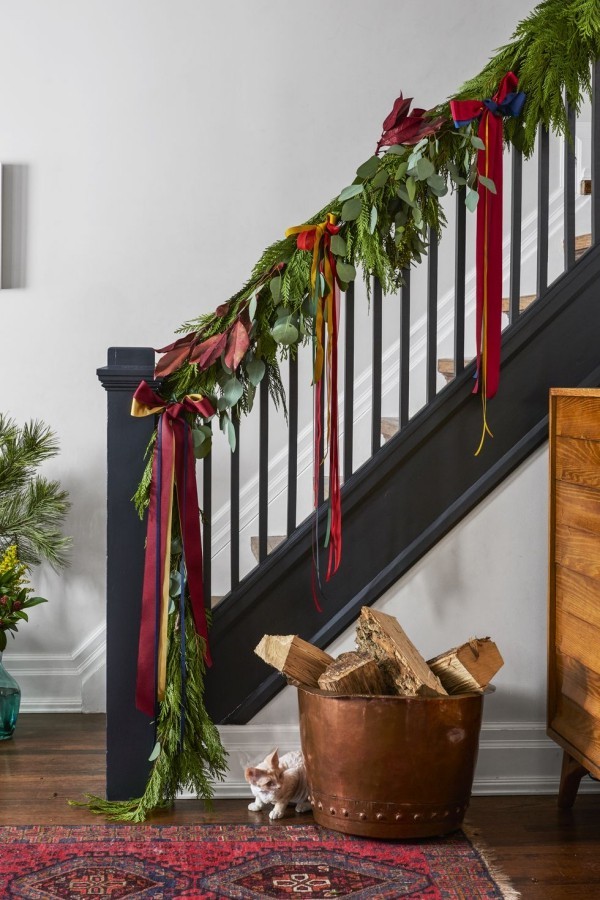 Weihnachtsdeko das Treppenhaus festlich dekorieren mit grünen Zweigen und roten Schleifen