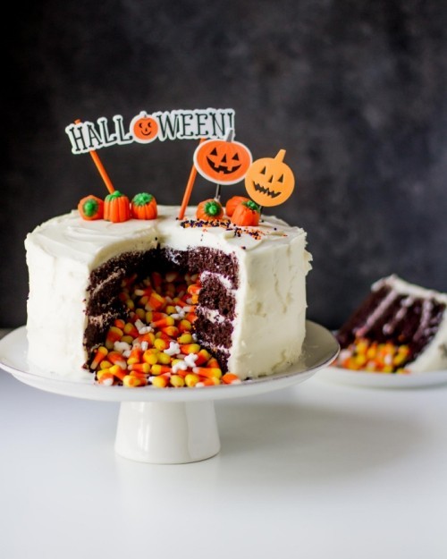 Weißer Kuchen mit kleinen Bonbons gefüllt kleine Kürbisse schöne Halloween Kuchen Deko