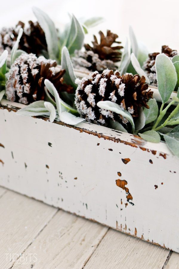 DIY Weihnachtsdeko Ideen alte Holzkiste voll mit schneebedeckten Zapfen viel Grün