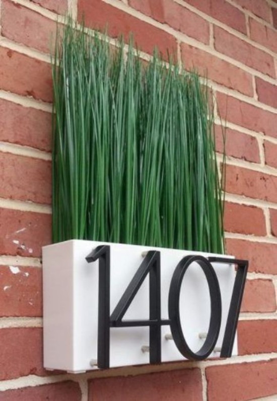 Hausnummern an modernen Häusern Blumenkasten grüne Pflanzen