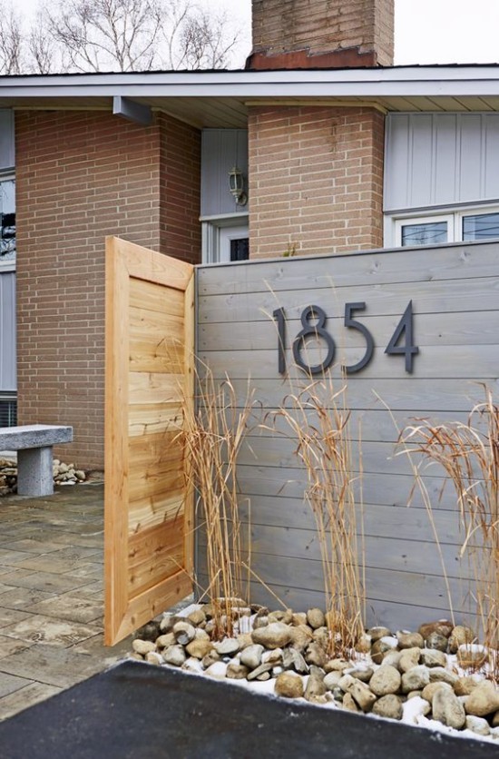Hausnummern an modernen Häusern direkt am Holzzaun