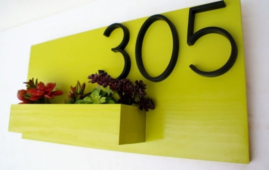 Hausnummern an modernen Häusern mit Blumenkasten kombiniert