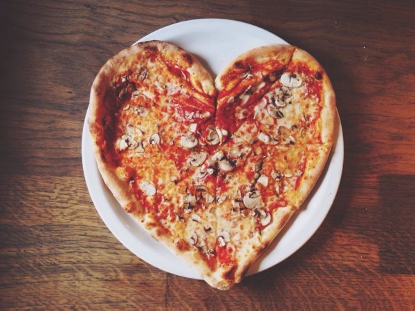 Romantik am Valentinstag zu zweit zu Hause eine Pizza in Herzform essen