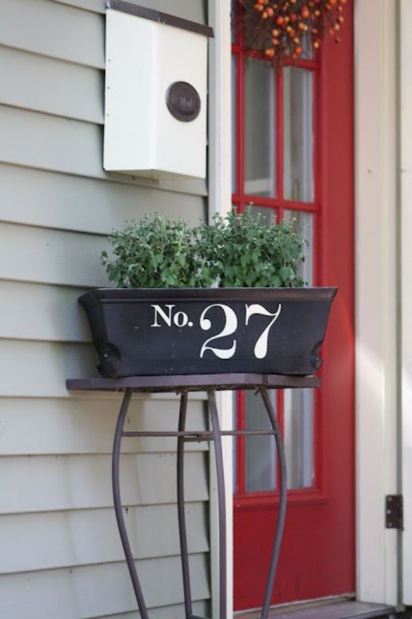 Ausgefallene Hausnummern auf Blumenkasten vor der Tür