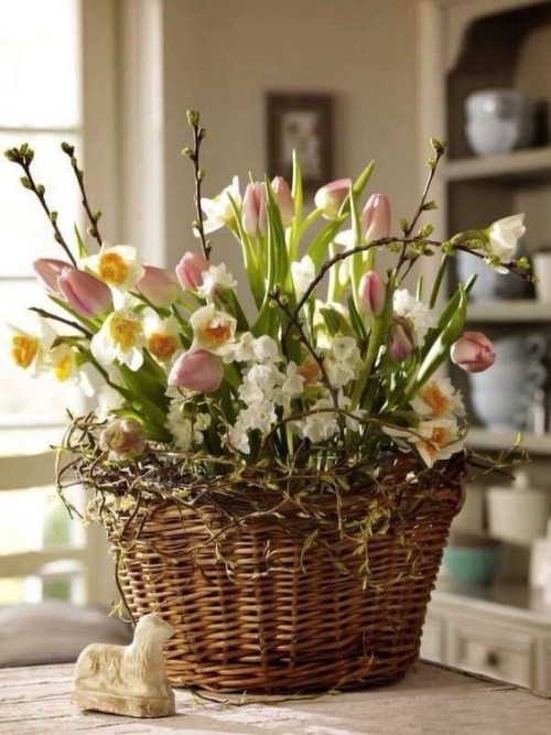 Blumendeko zu Ostern ein Korb aus Weinreben mit rosa Tulpen