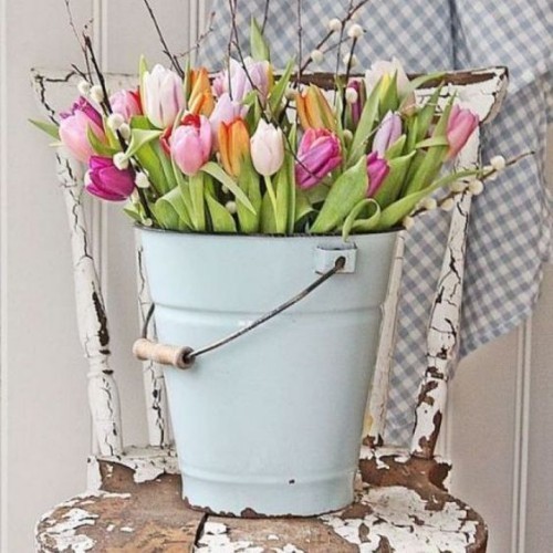 Blumendeko zu Ostern rustikale Osterdekoration blauer Eimer mit bunten Tulpen und Weidenkätzchen