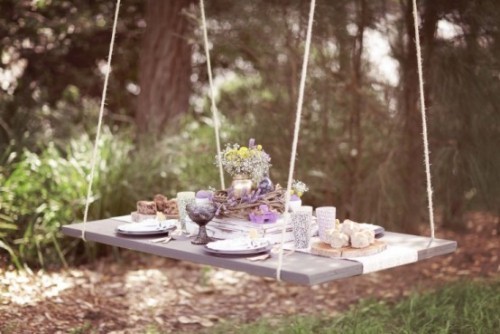 Rustikale Osterdeko aufgehängter Schaukeltisch im Garten Osterfeier im Freien