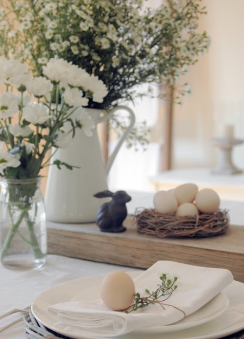 Rustikale Osterdeko weiße Blumen in Vasen Hase Eier Nest festlich gedeckter Tisch
