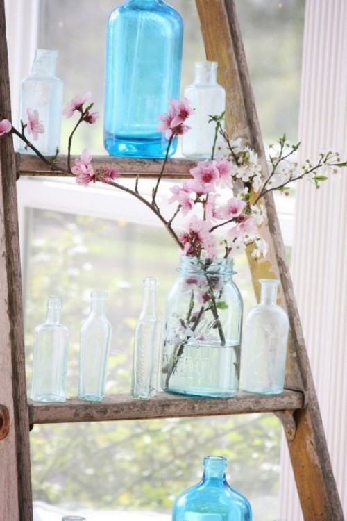 Wunderschöne Blumenarrangements zarte Magnolienzweige im Glas auf einer Vintage Leiter