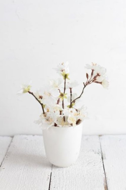 Wunderschöne Blumenarrangements zarte weiße Blüten Zweige in weißer Vase