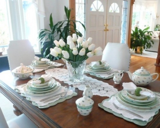 Stilvolle Tischdekoration weiße Tulpen in Vase feines Geschirr Häkeldecke