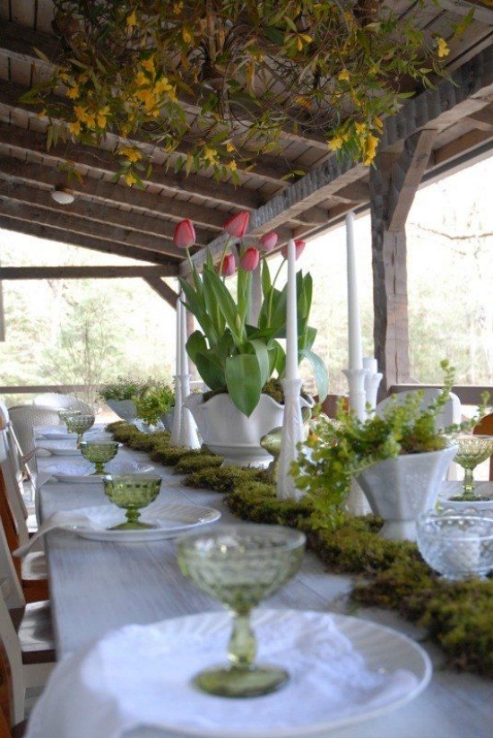 frühlingshafte Tischdekoration Moos auf dem Tisch rote Tulpen in Vase
