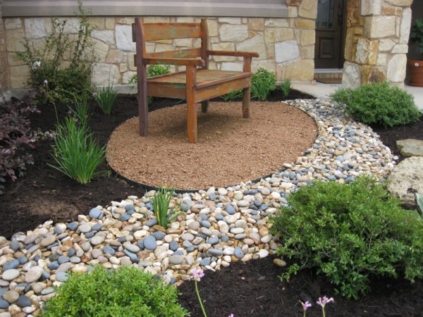 Garden with ornamental gravel, small seating area, bench, stones, green plants