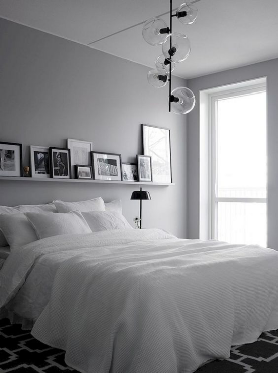 Schlafzimmer Ideen im Scandi Style Naturweiß Bettdecke Kissen Teppich in Schwarz mit geometrischen Mustern Lampen Regal für Bilder