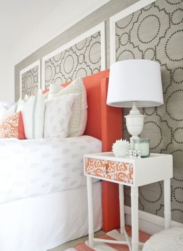 Grau und Koralle im Interieur perfektes Schlafzimmer hohes Bett Bettkopfteil Akzentwand weiße Lampe Nachttisch