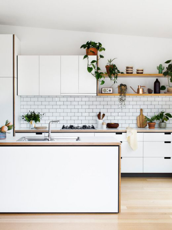 Skandinavische Küche rustikales Flair grüne Pflanzen helles Holz geflieste Küchenrückwand sehr ansprechende Atmosphäre
