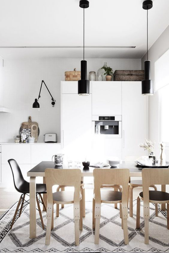 Skandinavische Küche rustikales Flair schwarz und weiß im Farbduo etwas helles Holz Stilmix verschiedene Stühle Hängeleuchte