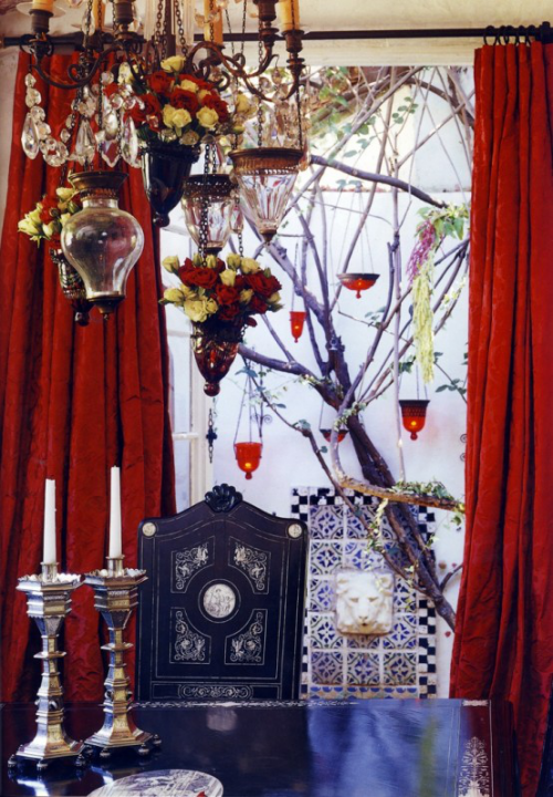 Boho chic in the dining room blood-red curtains as a background colorful lamps lanterns